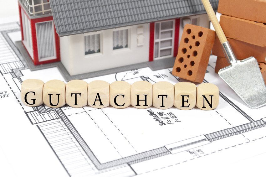 Haus-Modell mit Grundriss und dem Wort Gutachten